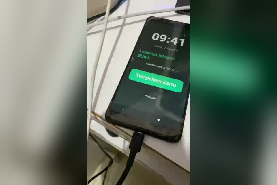 HP kiosk Silah di layar utama: jam, status layanan telepon buka, dan tombol Tempelkan Kartu